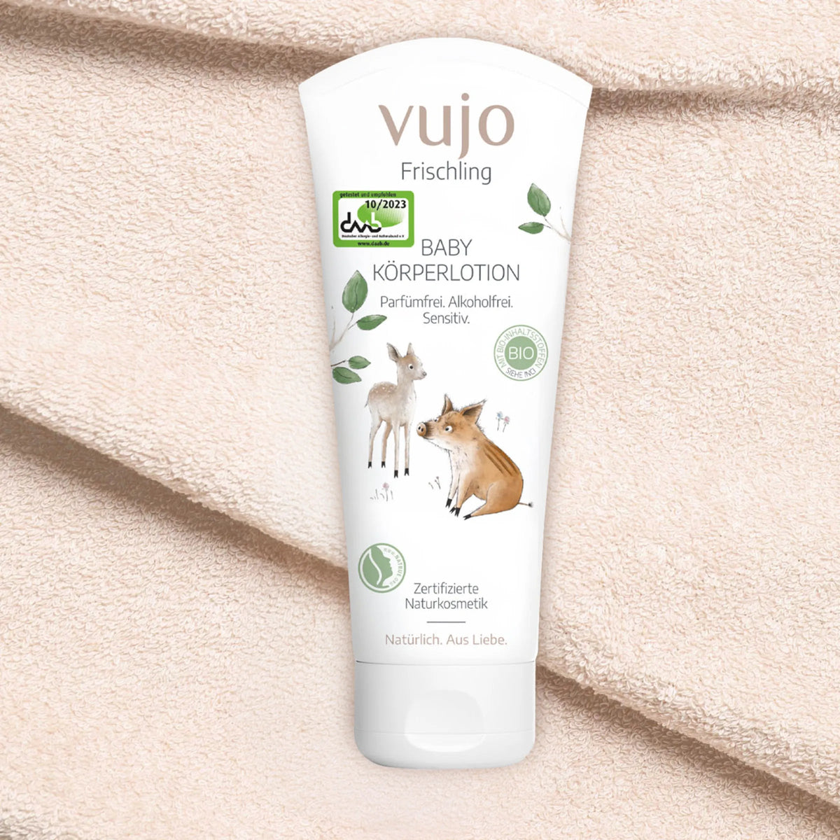 vujo Baby Körperlotion Tube auf weichem Frotteetuch