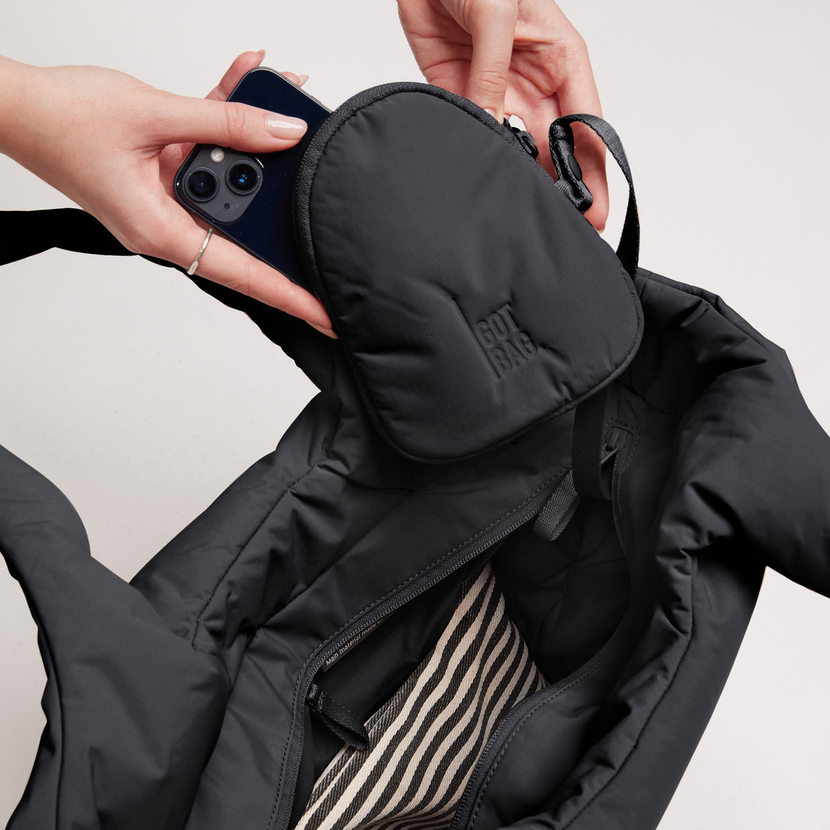 GOT BAG Cloud Tote Bag Shopper in Schwarz, eine Frau steckt ihr Handy in die Tasche