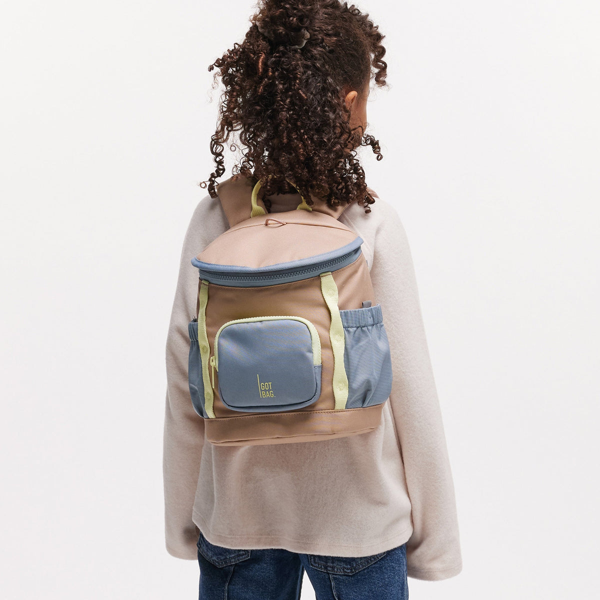 GOT BAG Kids Adventure Daypack Kinderrucksack in Beige (sandbar), von einer Person auf dem Rücken getragen
