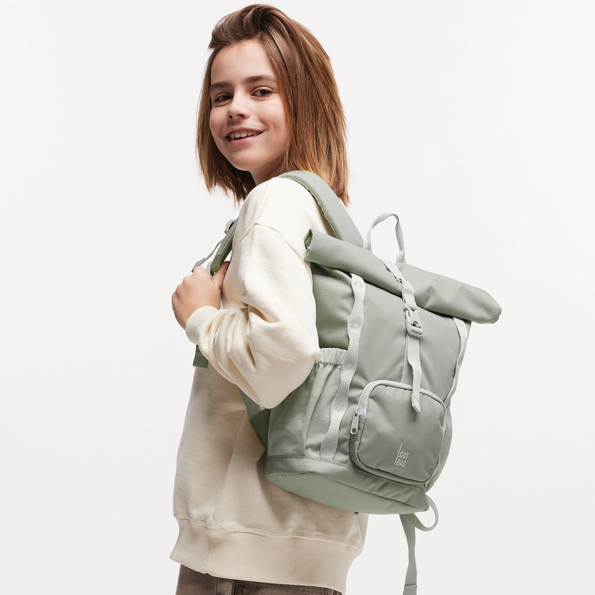 GOT BAG Kids Adventure Rolltop Kinderrucksack in Salbeigrün (bass), von einem Mädchen auf dem Rücken getragen