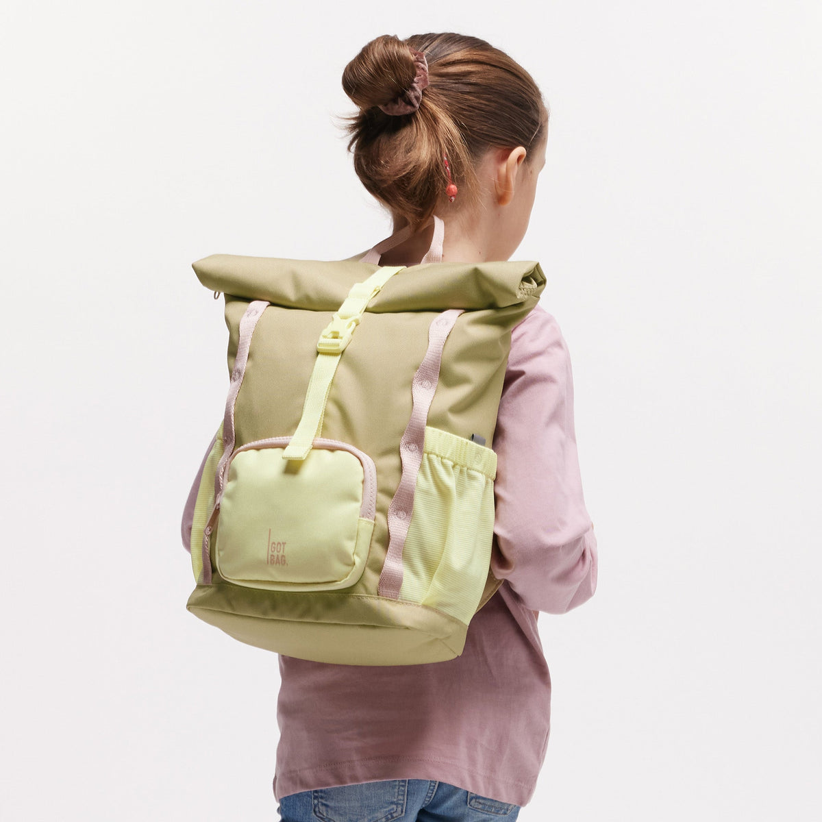 GOT BAG Kids Adventure Rolltop Kinderrucksack in Pistaziengrün (nori), von einem Mädchen auf dem Rücken getragen