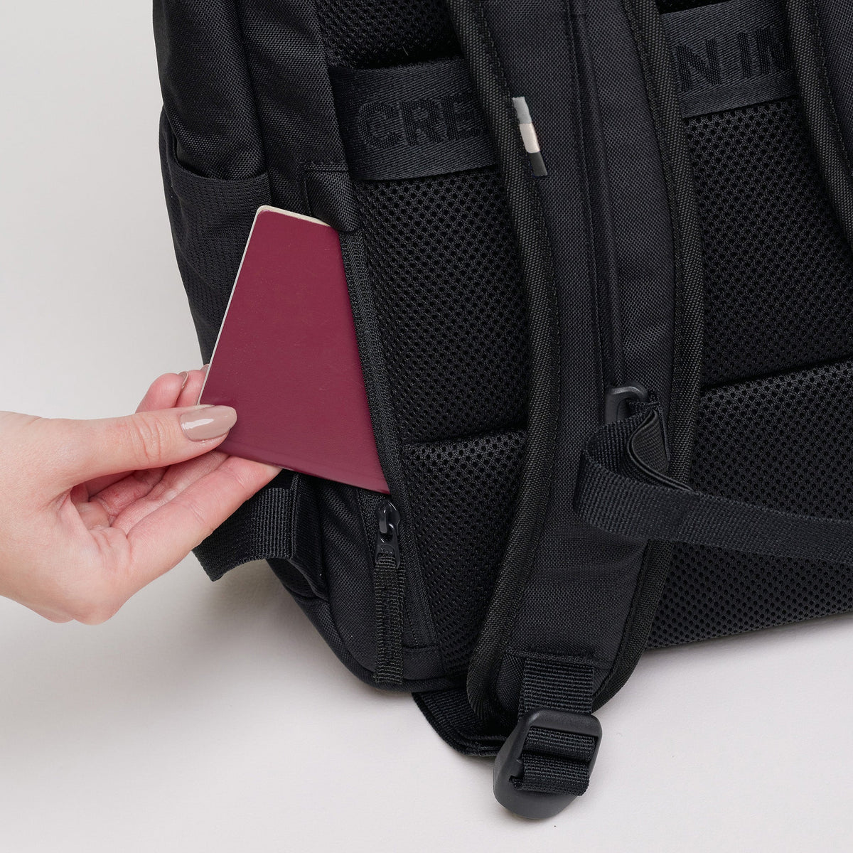 GOT BAG Pro Pack Laptoprucksack in Schwarz (Monochrome), eine Hand steckt einen Pass in die verdeckte Tasche