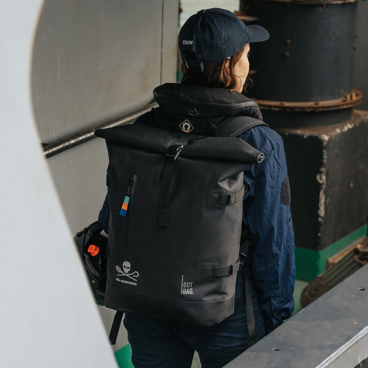 GOT BAG Rolltop 2.0 Rucksack Sea Shepherd Edition in Schwarz, von einer Frau auf dem Rücken getragen, mit Sea-Shepherd-Logo