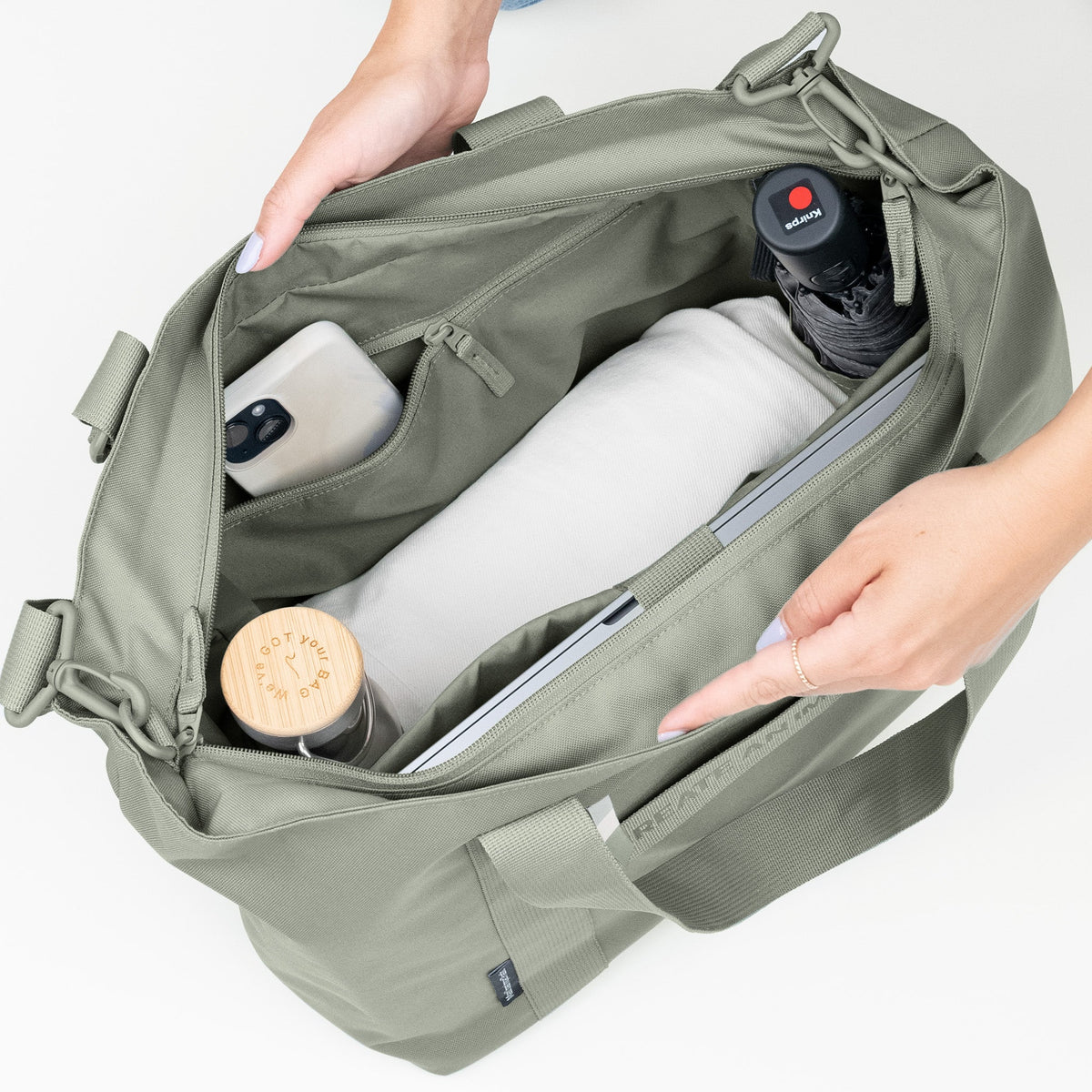 GOT BAG Tote Bag Monochrome Tragetasche in Salbeigrün (bass), eine Frau organisiert den Inhalt im offenen Hauptfach