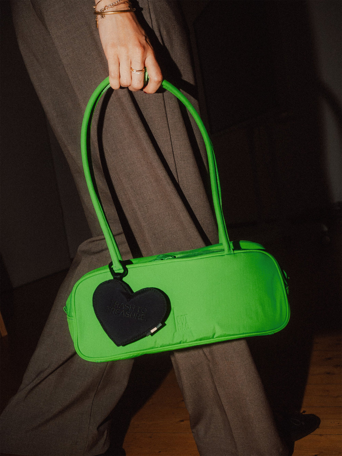GOT BAG Treasure Charm Herzanhänger in Schwarz, an einer Tasche, von einer Person in der Hand gehalten