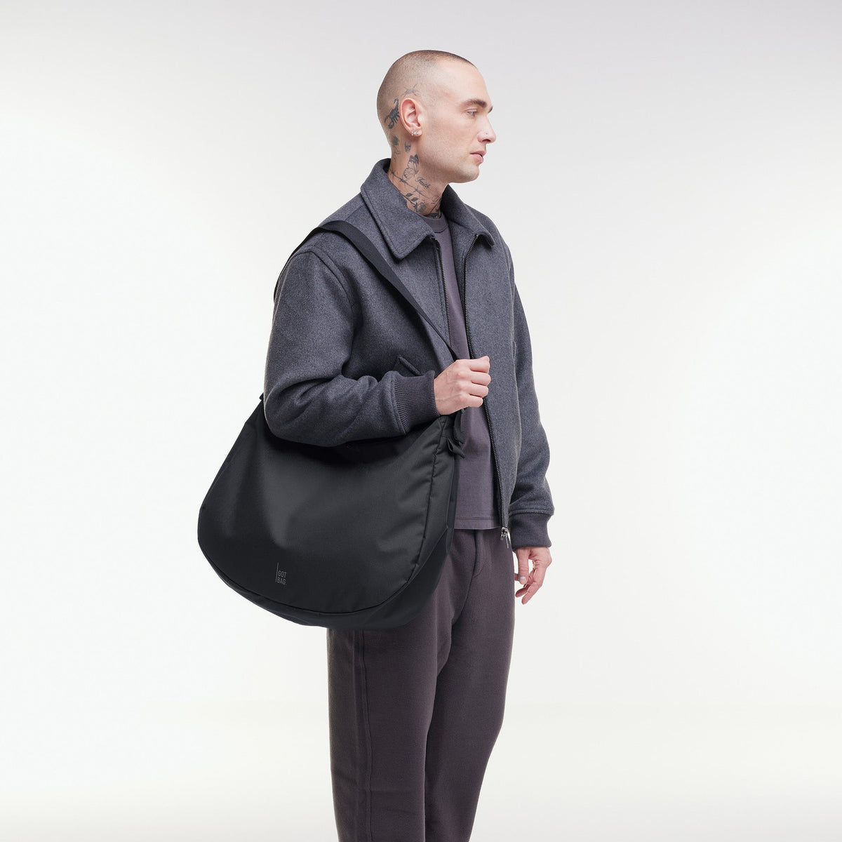 GOT BAG Curved Bag Monochrome Schultertasche in Schwarz, von einem Mann über der Schulter getragen