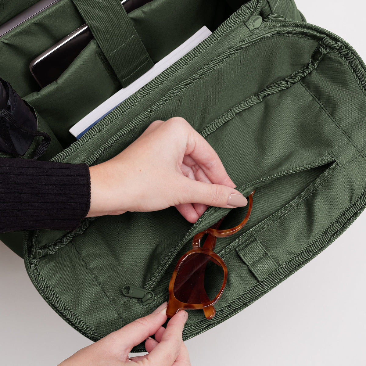 GOT BAG Pro Pack Laptoprucksack in Dunkelgrün (algae), eine Hand greift in die Reißverschlusstasche