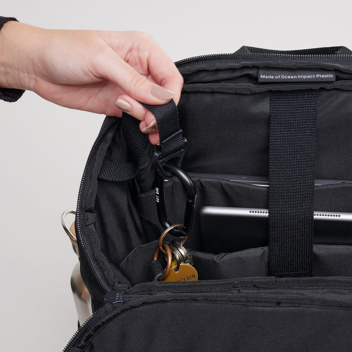 GOT BAG Pro Pack Laptoprucksack in Schwarz (Monochrome), eine Frau hängt einen Schlüsselbund in die Innentasche