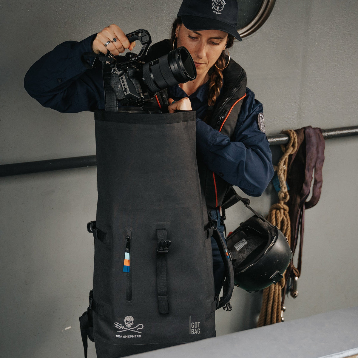 GOT BAG Rolltop 2.0 Rucksack Sea Shepherd Edition in Schwarz, wird von einer Frau befüllt